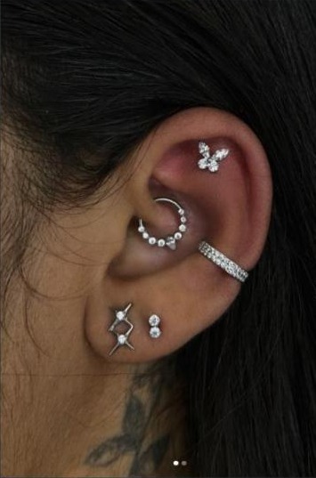 Composição de piercings de orelha em titânio e prata, trabalho do Studio Janette