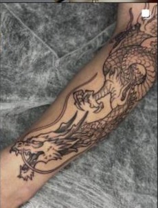Tatuagem blackwork de dragão na perna, trabalho do Studio Janette